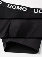 Détails de la ceinture UOMO, des coutures et de la jambe d’un boxer noir.